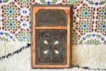 Bone inlay mirror decorated with orange and white camel bone pieces hanging on the wall
