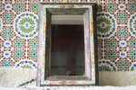 Moroccan mirror with bones engraved and colored set on the mosaic wall