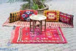 Coussin Boho sur un tapis vintage et une table en laiton au centre