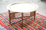 Round coffee table base shaped in X and folding with brass tray