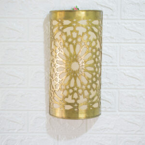 brass wall sconce with geometric design hanging on a white wall background