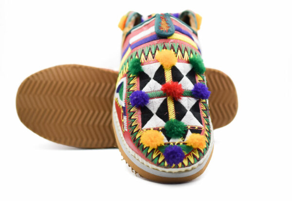 Pantoufles marocaines avec des motifs berbères et des pompons colorés