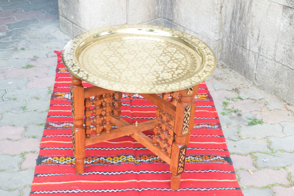 Moroccan Brass coffee table stand on red Berber rug